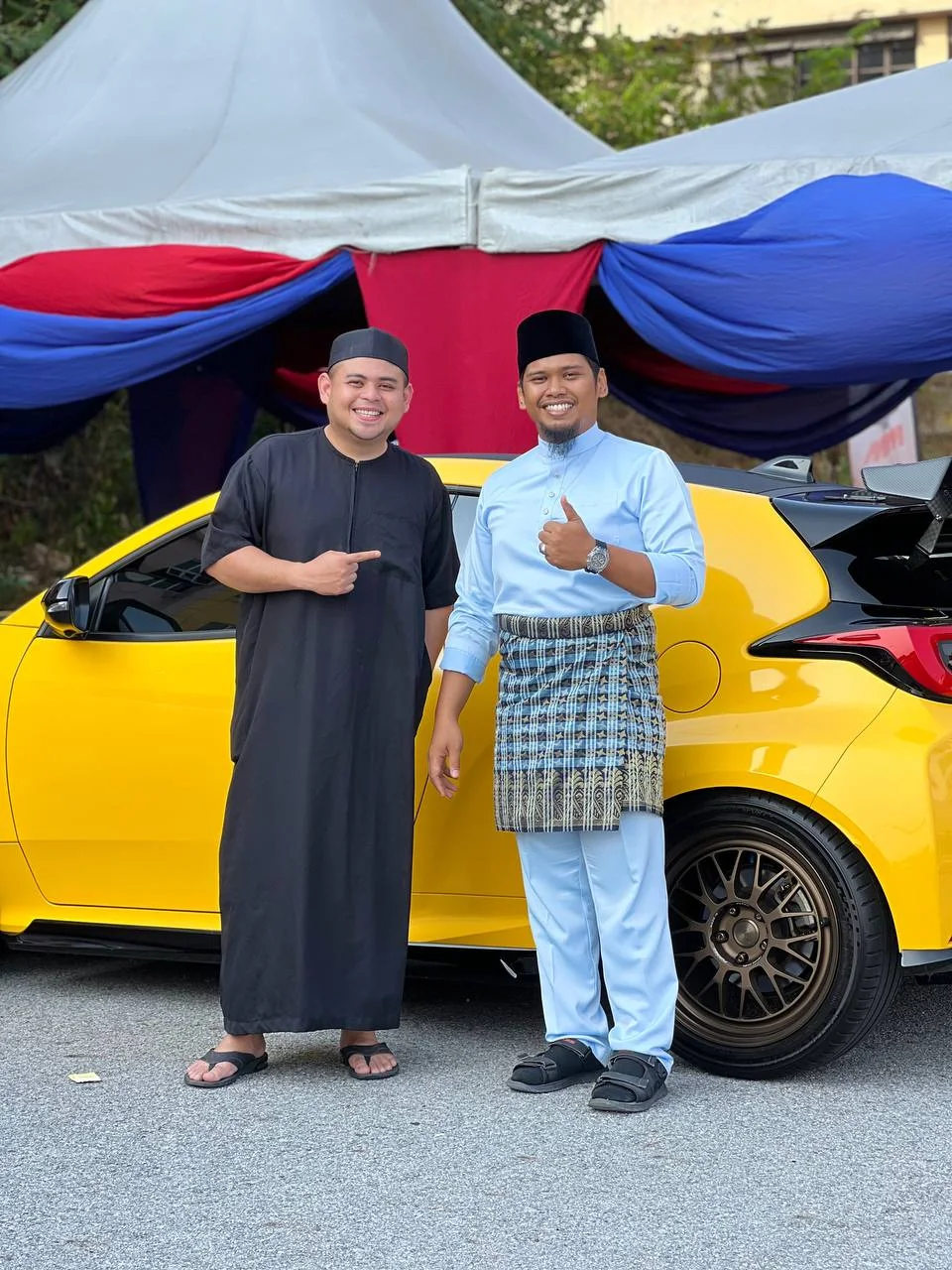 Two ASG community members beside a yellow performance hatchback