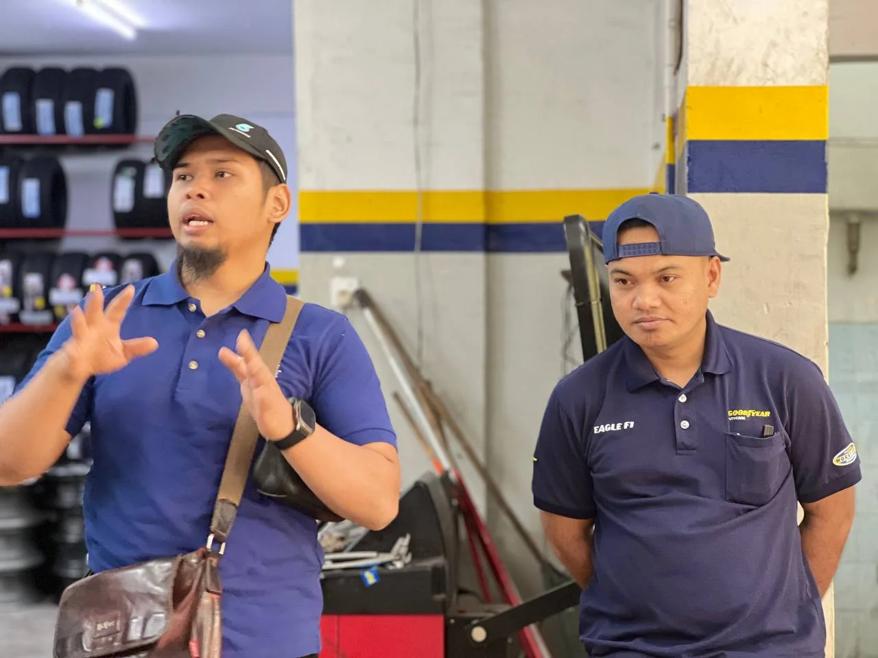 Two ASG team members in conversation inside the tyre workshop