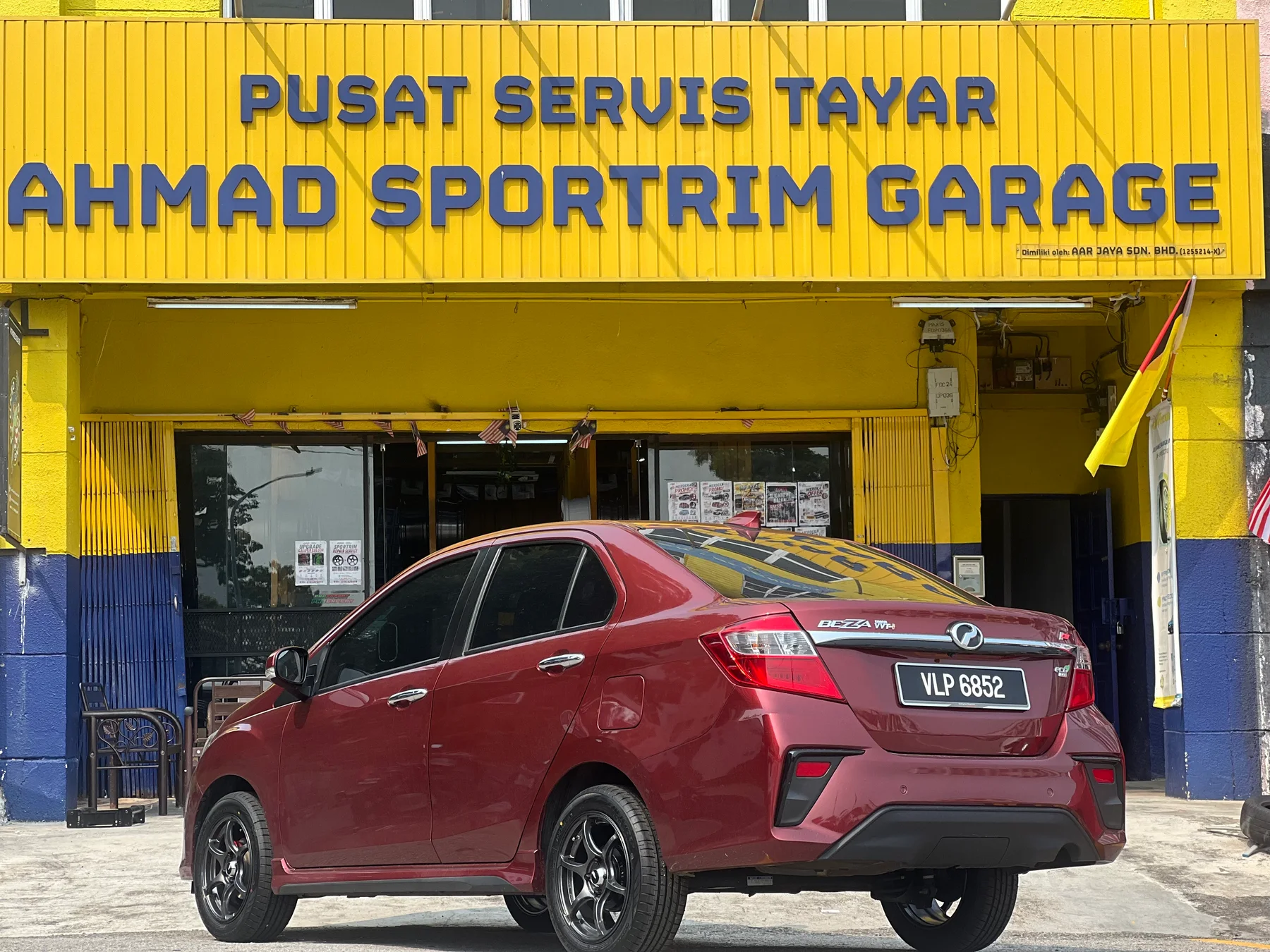 Red Perodua Bezza parked outside Ahmad Sportrim Garage