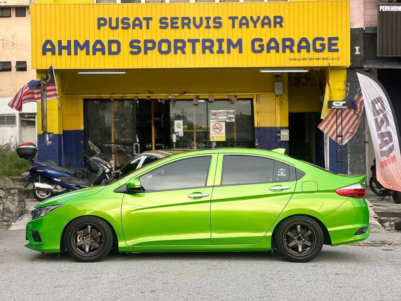 Lime green Honda City side profile with bronze wheels outside ASG