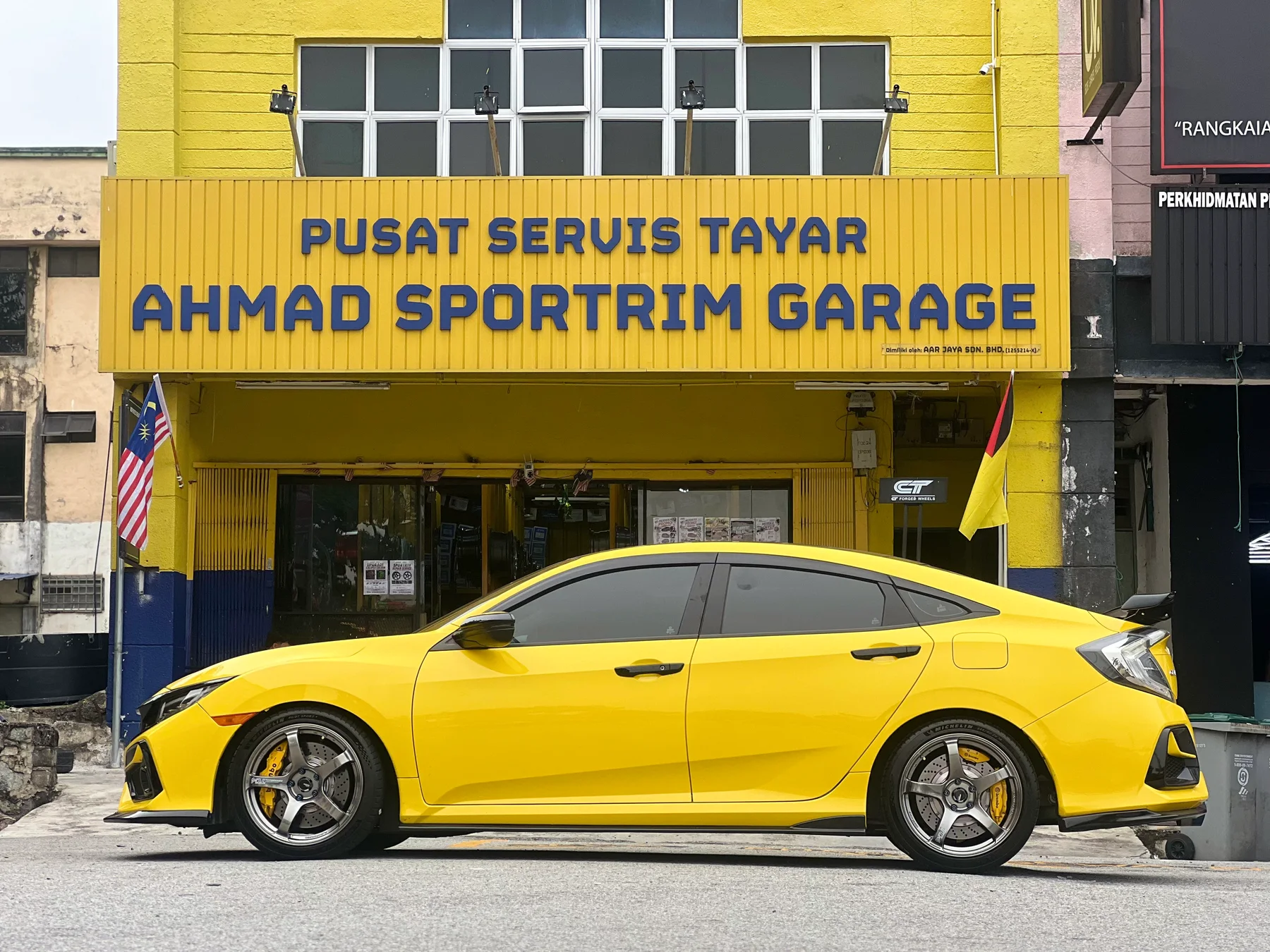 Yellow Honda Civic sedan with dark multi-spoke wheels outside ASG