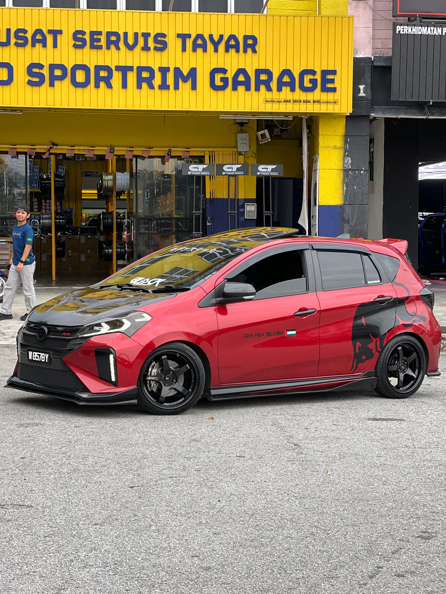 Red Perodua Myvi with black multi-spoke wheels at Ahmad Sportrim Garage