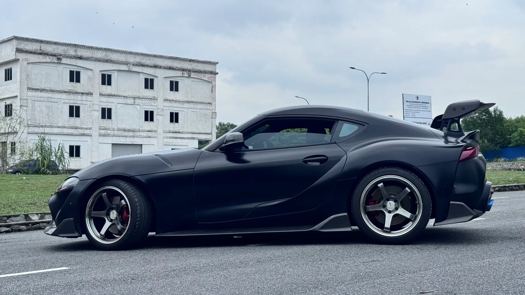 Dark Toyota Supra with silver six-spoke wheels