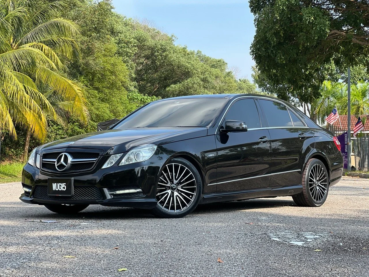 Black Mercedes-Benz E-Class sedan with aftermarket multi-spoke wheels