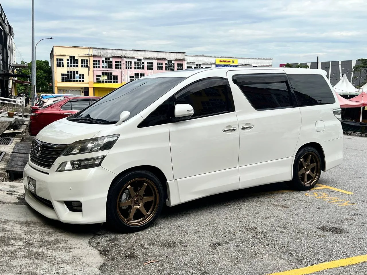 White Toyota Vellfire with bronze six-spoke wheels