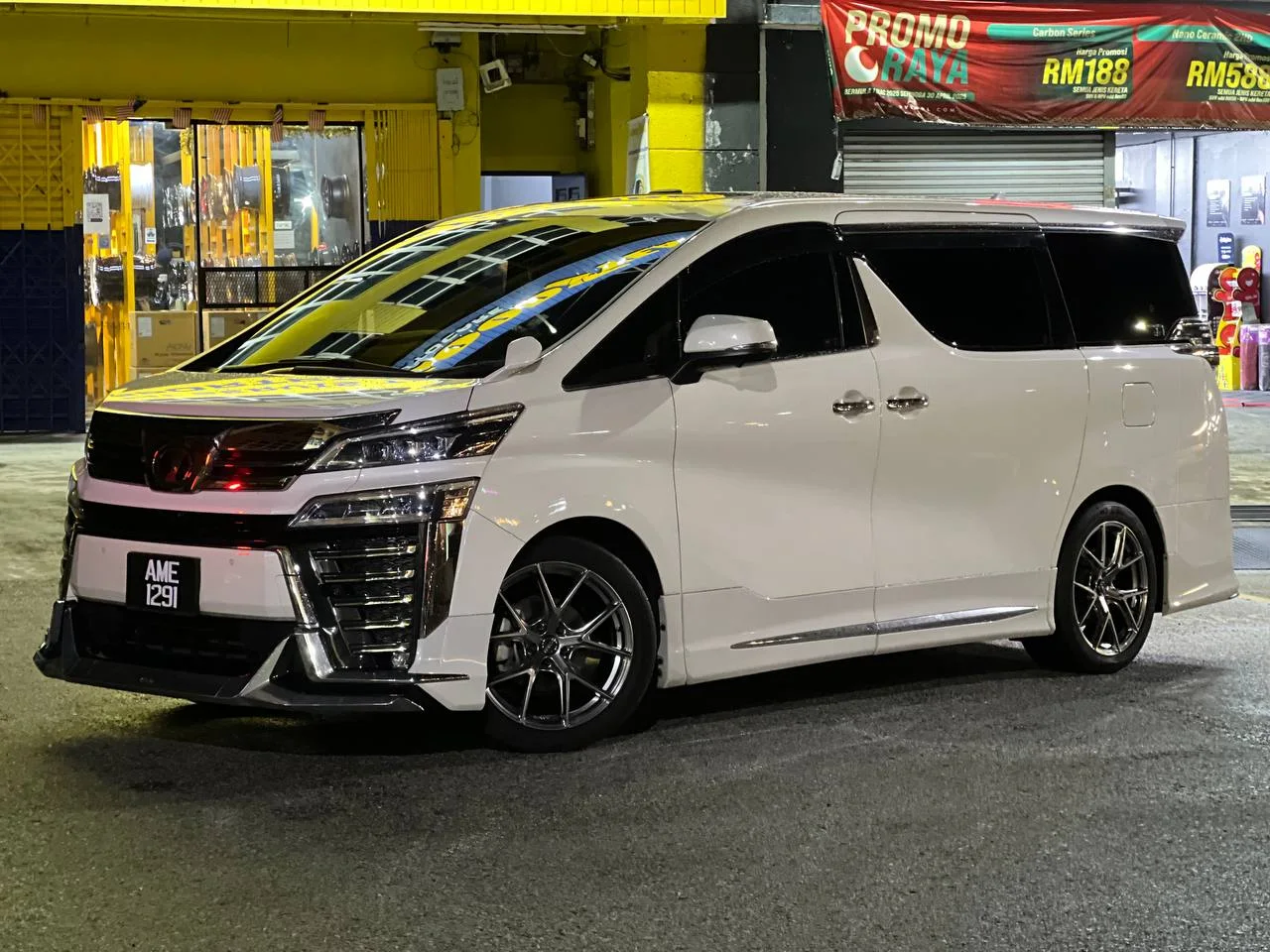 White Toyota Vellfire with aftermarket multi-spoke wheels