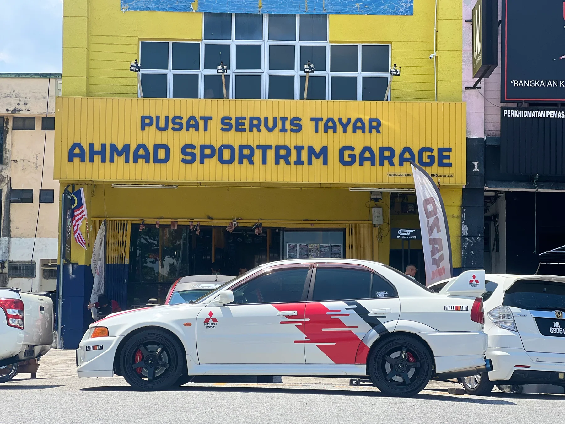 White Mitsubishi Lancer Evolution with Ralliart graphics and dark performance wheels