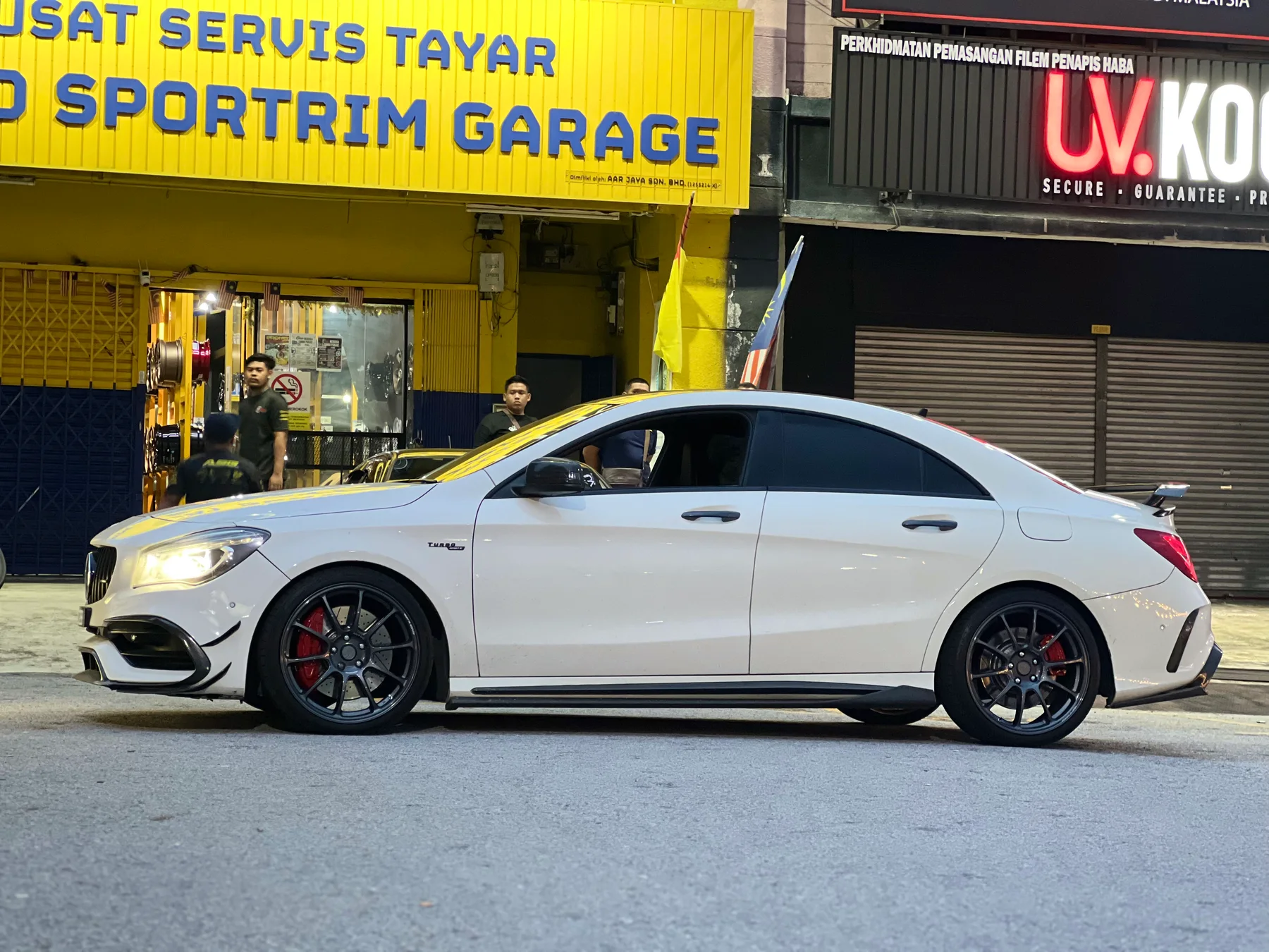 White Mercedes-Benz sedan with dark multi-spoke wheels outside ASG