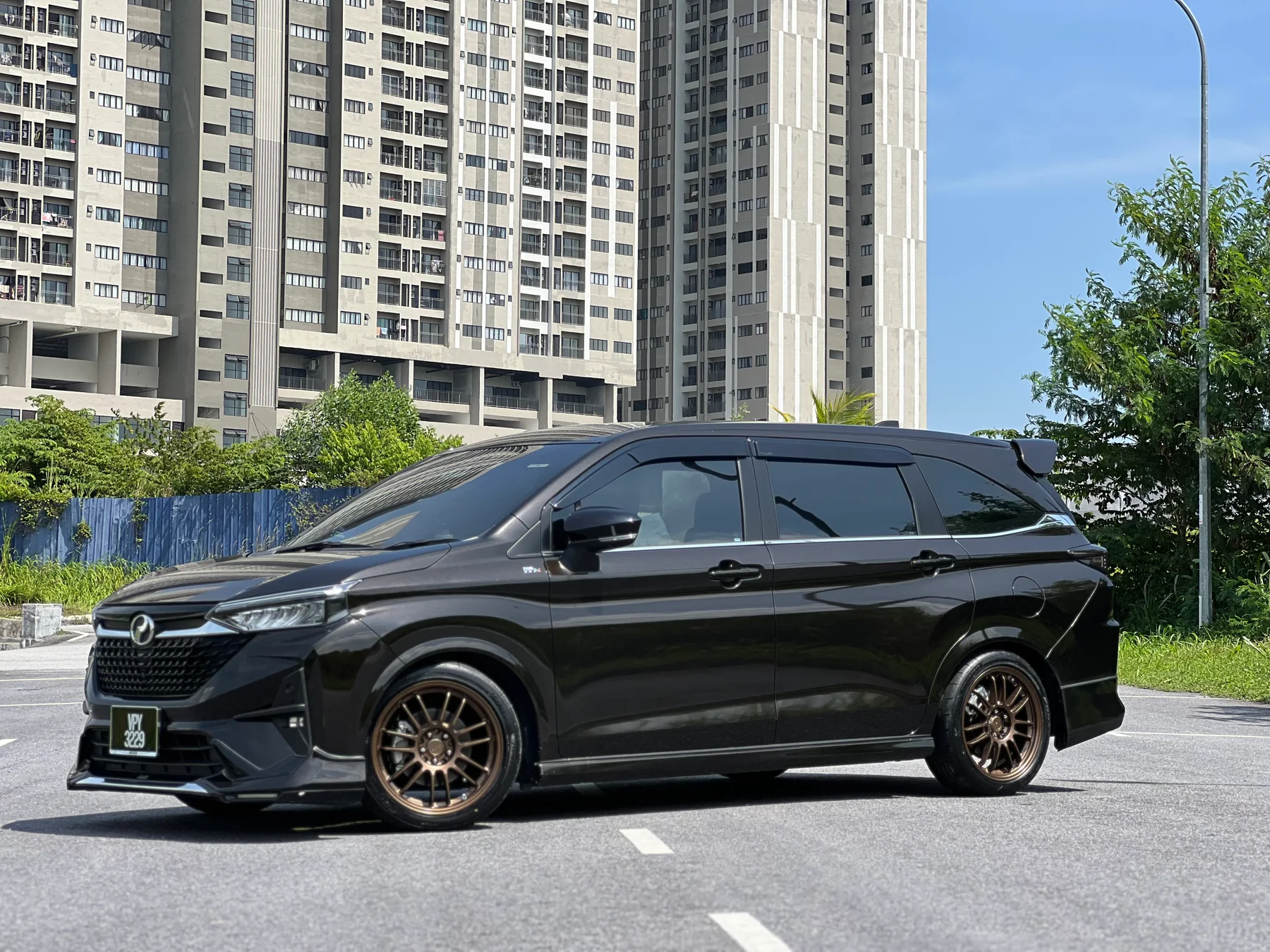 Black Toyota luxury MPV with bronze multi-spoke wheels