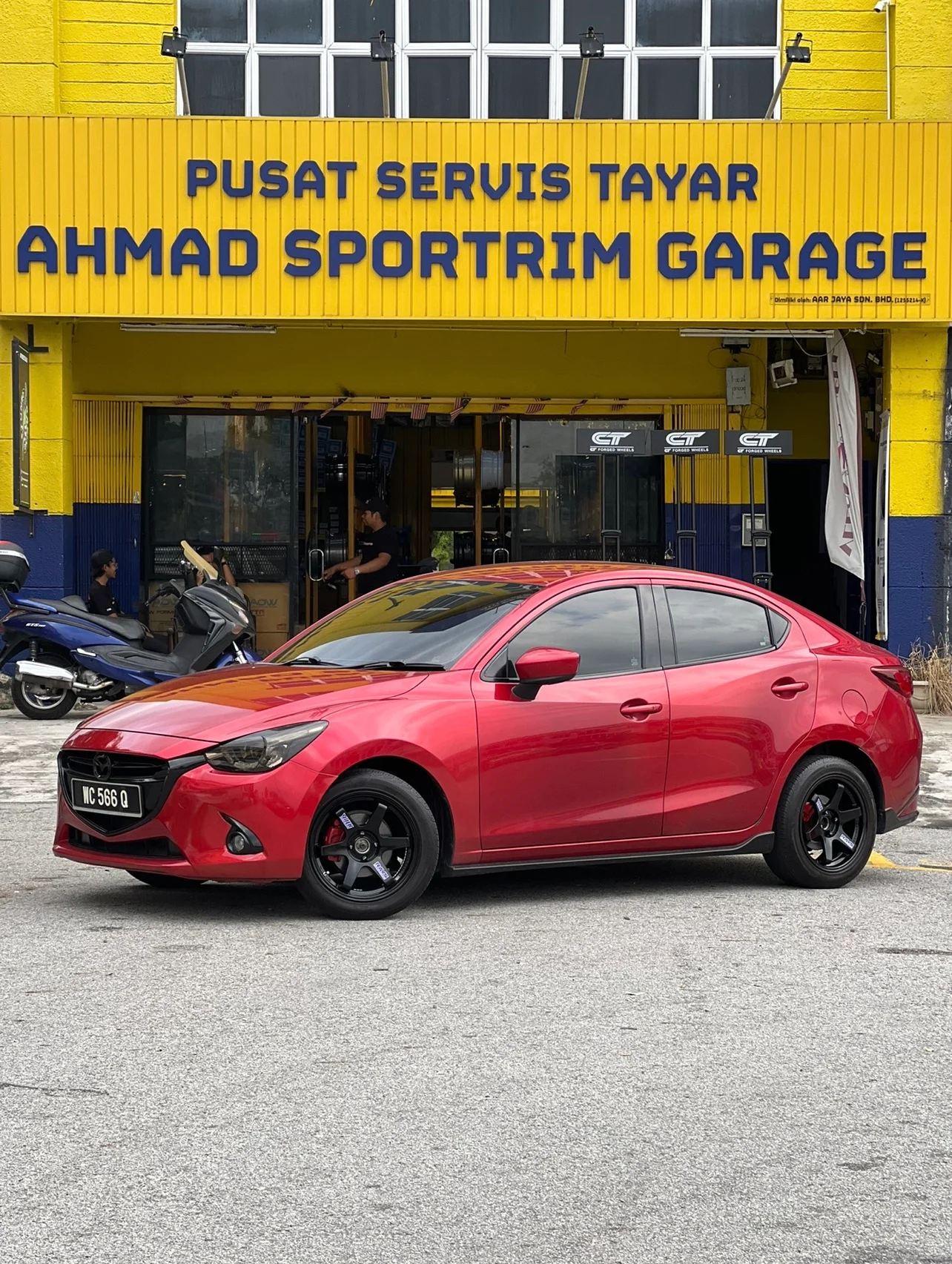 Red Mazda crossover with dark performance wheels outside ASG