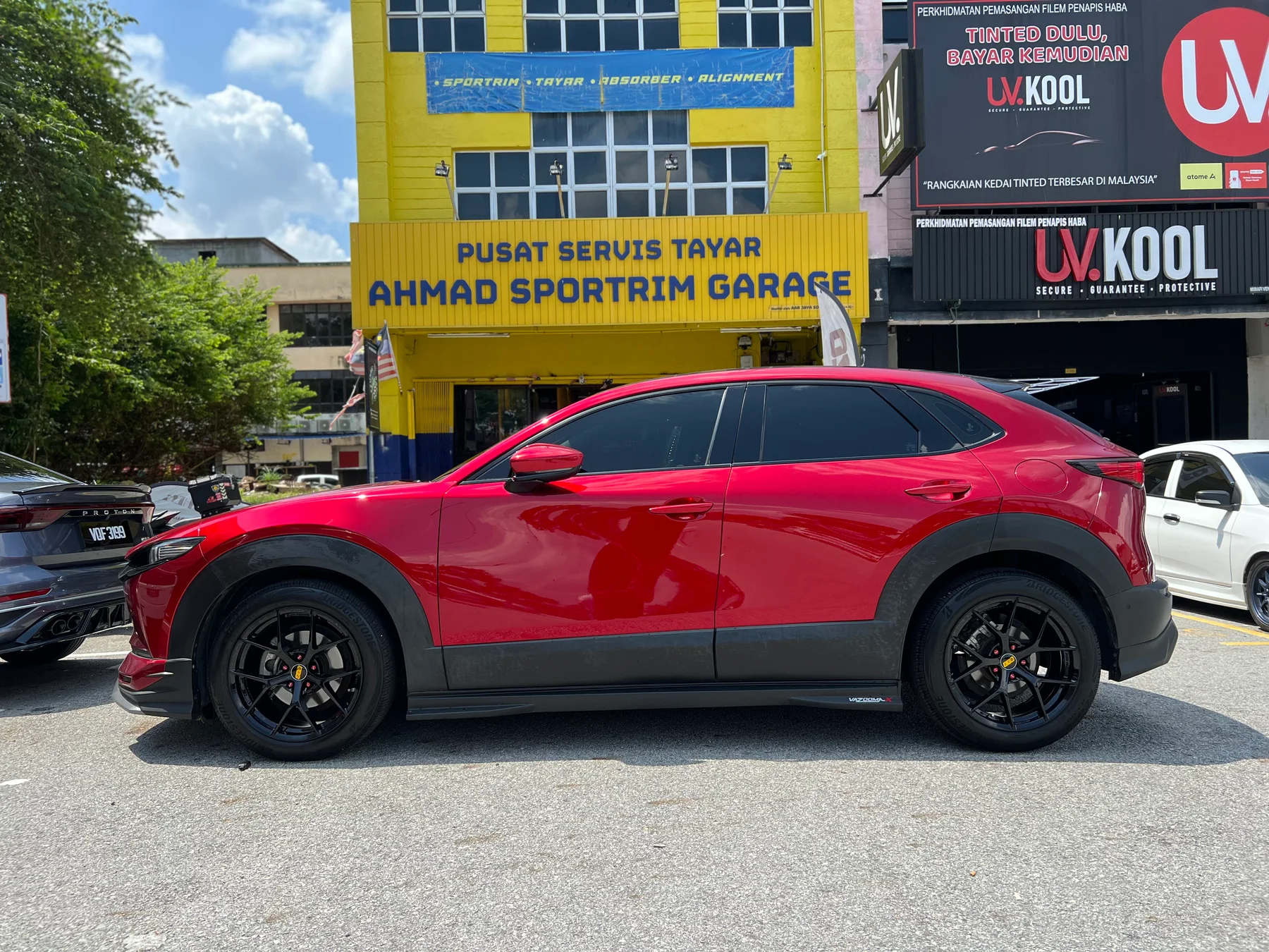 Red Mazda CX-30 with black multi-spoke wheels outside ASG