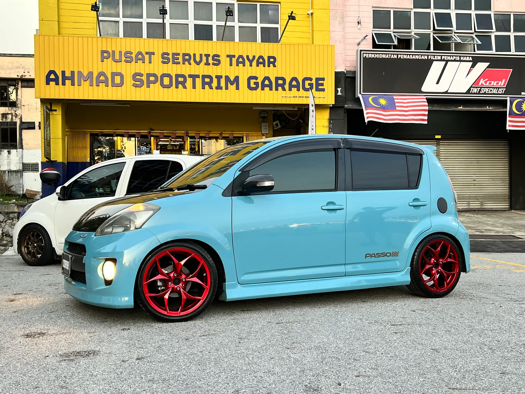 Light blue Toyota Passo with red performance wheels outside Ahmad Sportrim Garage