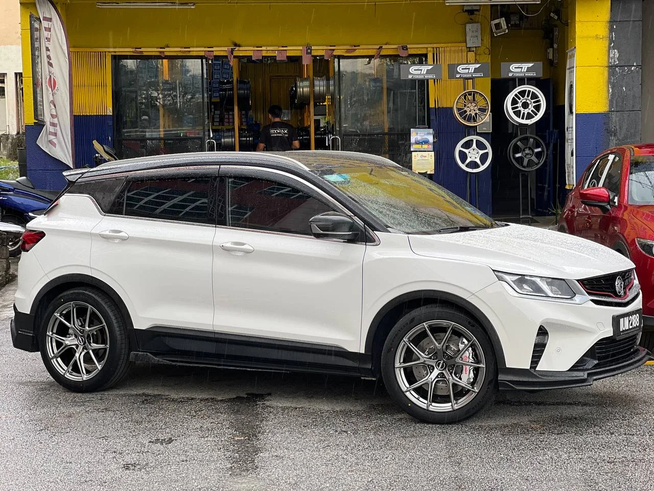 White Proton SUV with silver split-spoke wheels outside ASG