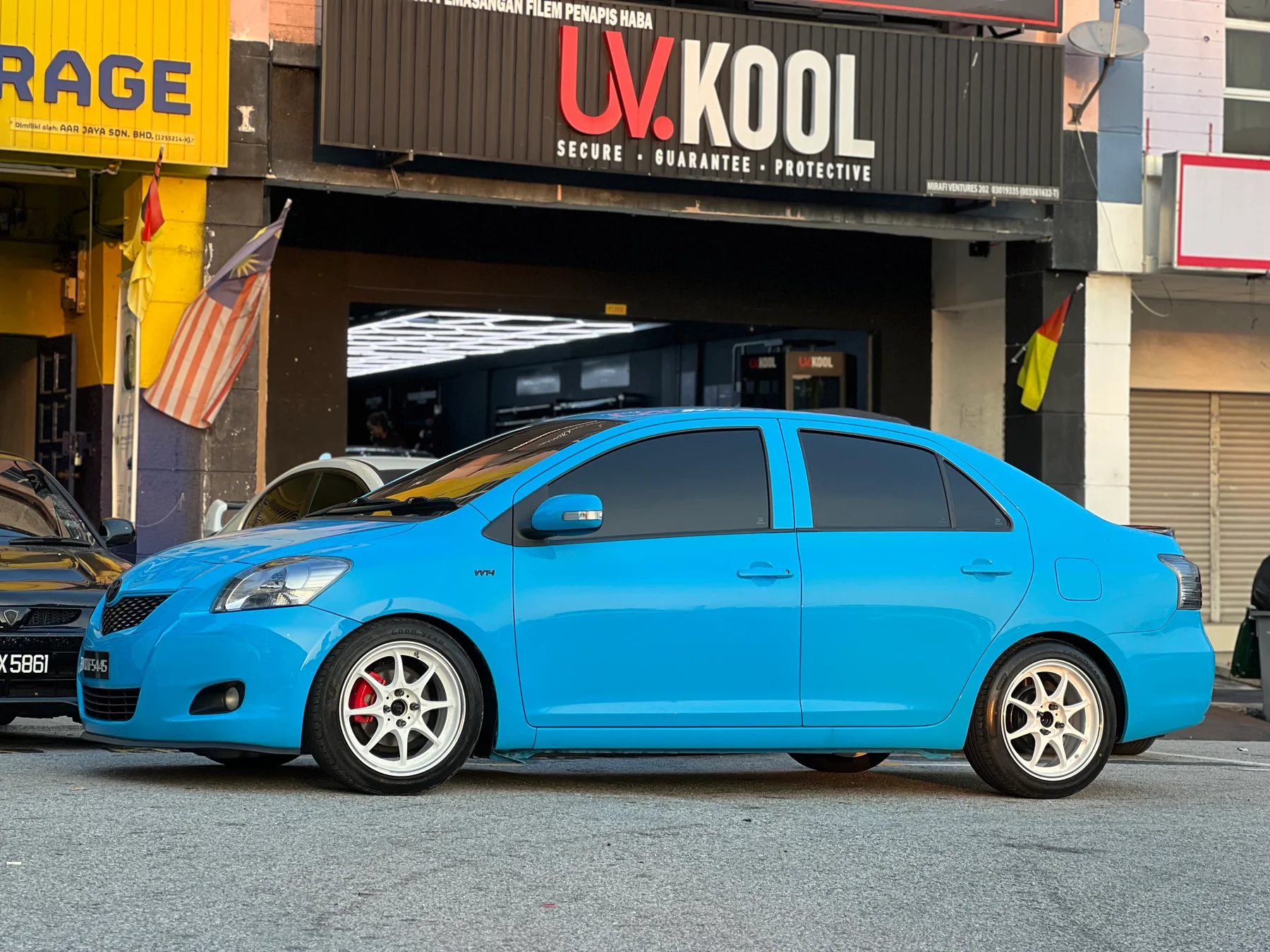 Blue Toyota Vios side profile with white multi-spoke wheels